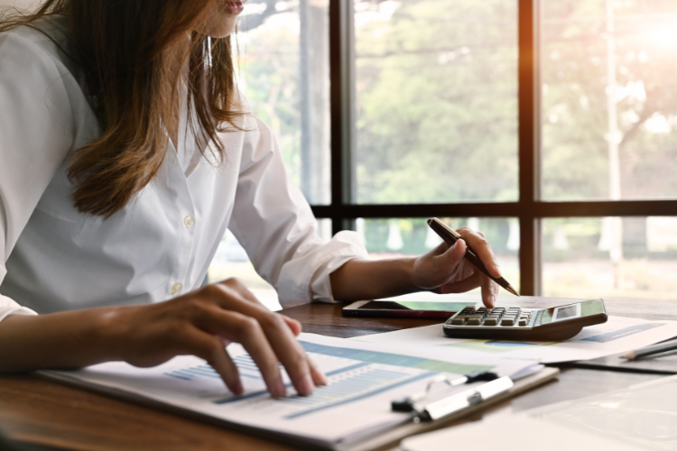 Business women using a calculator at her desk