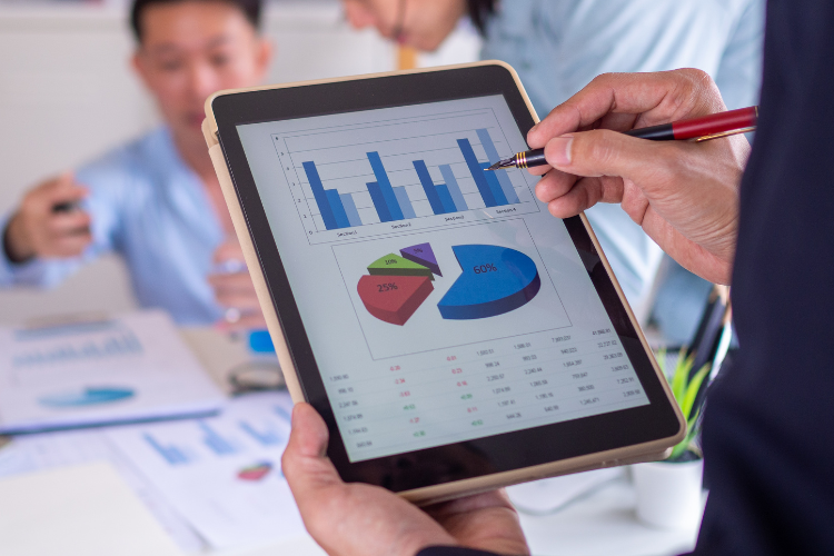 Professional holding an iPad with a chart of business statistics