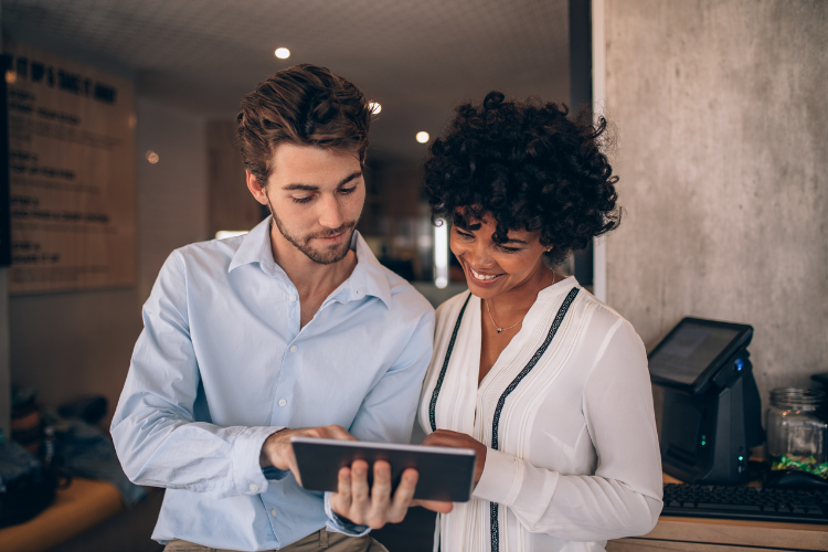 two business professionals look at an ipad