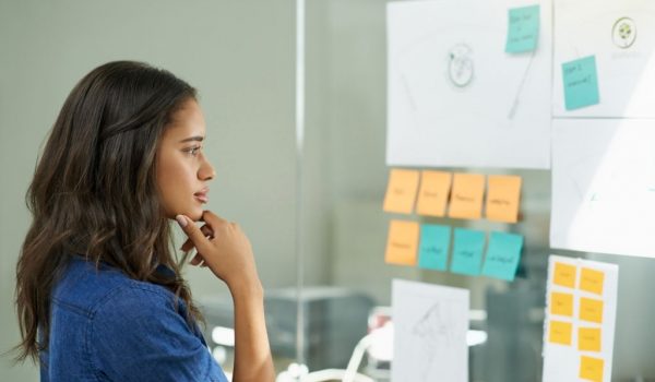 Cropped shot of a young woman brainstorming with sticky notes at work