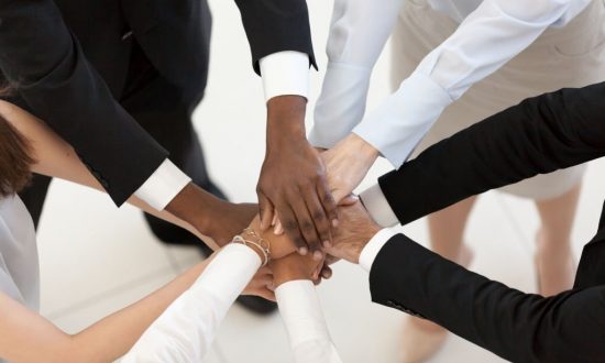 Diverse business people group put hands together in stack pile at training as concept of sales team corporate unity connection, teambuilding loyalty, support in teamwork, coaching, close up top view