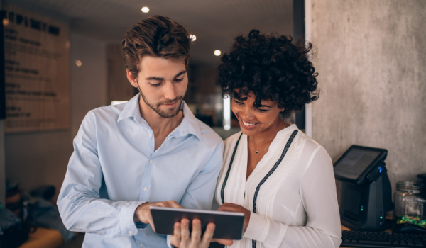 two business professionals look at an ipad