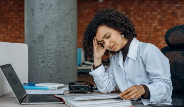 A women with curly hair looking stressed while reading at work